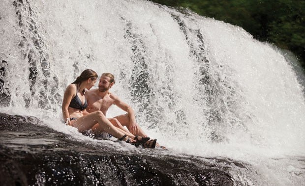 Swimmers cool off under a natural waterfall. Photo: Steven McBride