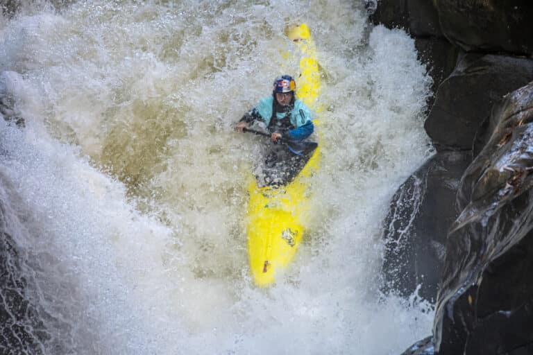 Evy Leibfarth goes straight down a huge whitewater drop called Gorilla rapid. The picture shows how intense the water is and how steep the drop is by showing Evy's entire boat she she paddles through it.